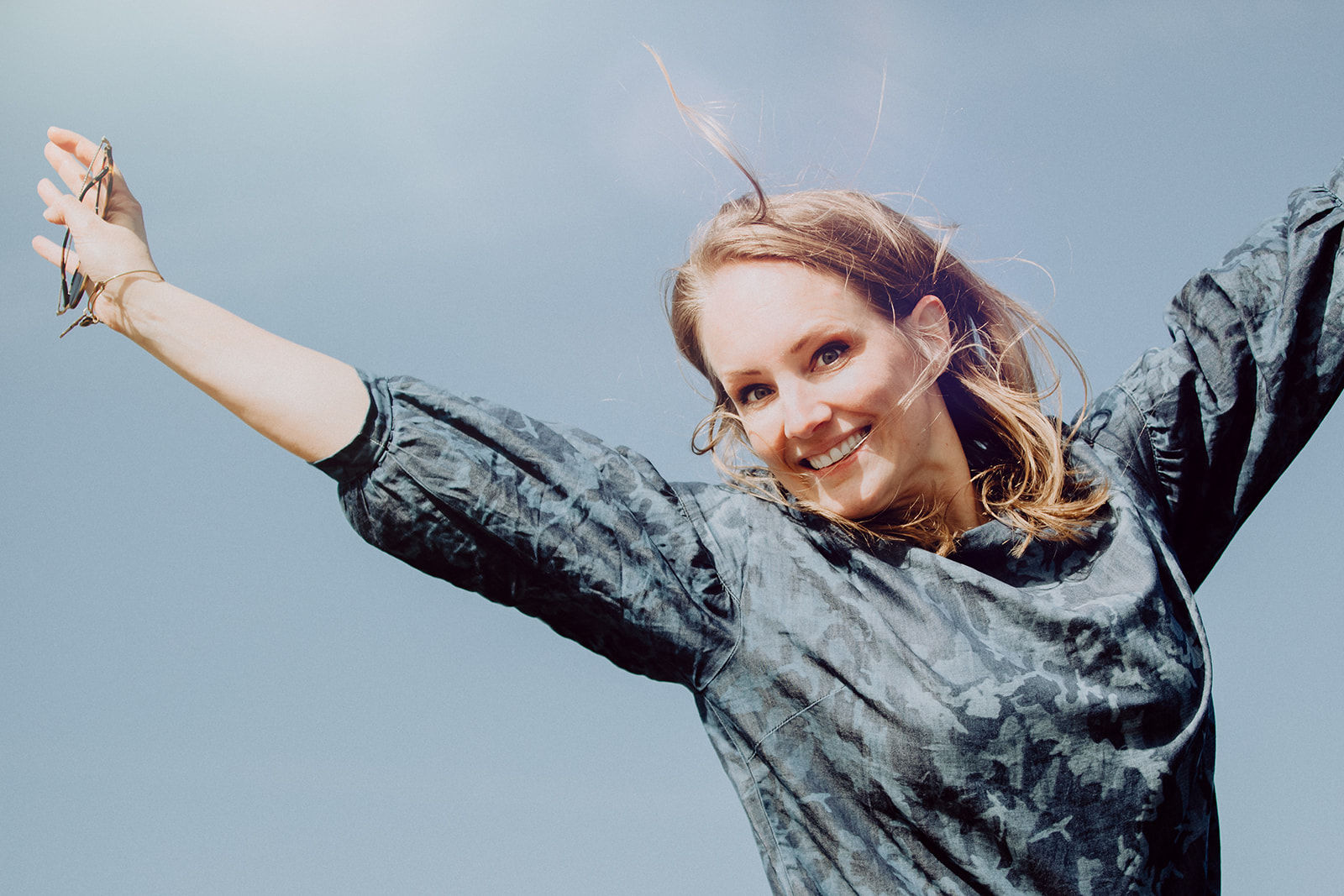A woman with her arms outstretched in the air, representing team development and resilience.