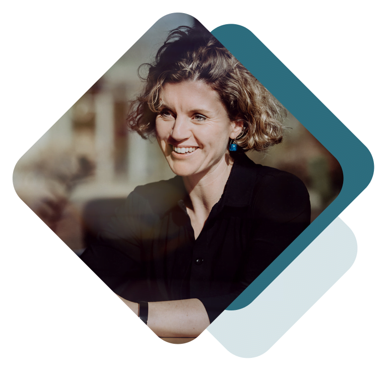 Een afbeelding van een glimlachende vrouw voor een plein, die teamontwikkeling laat zien.