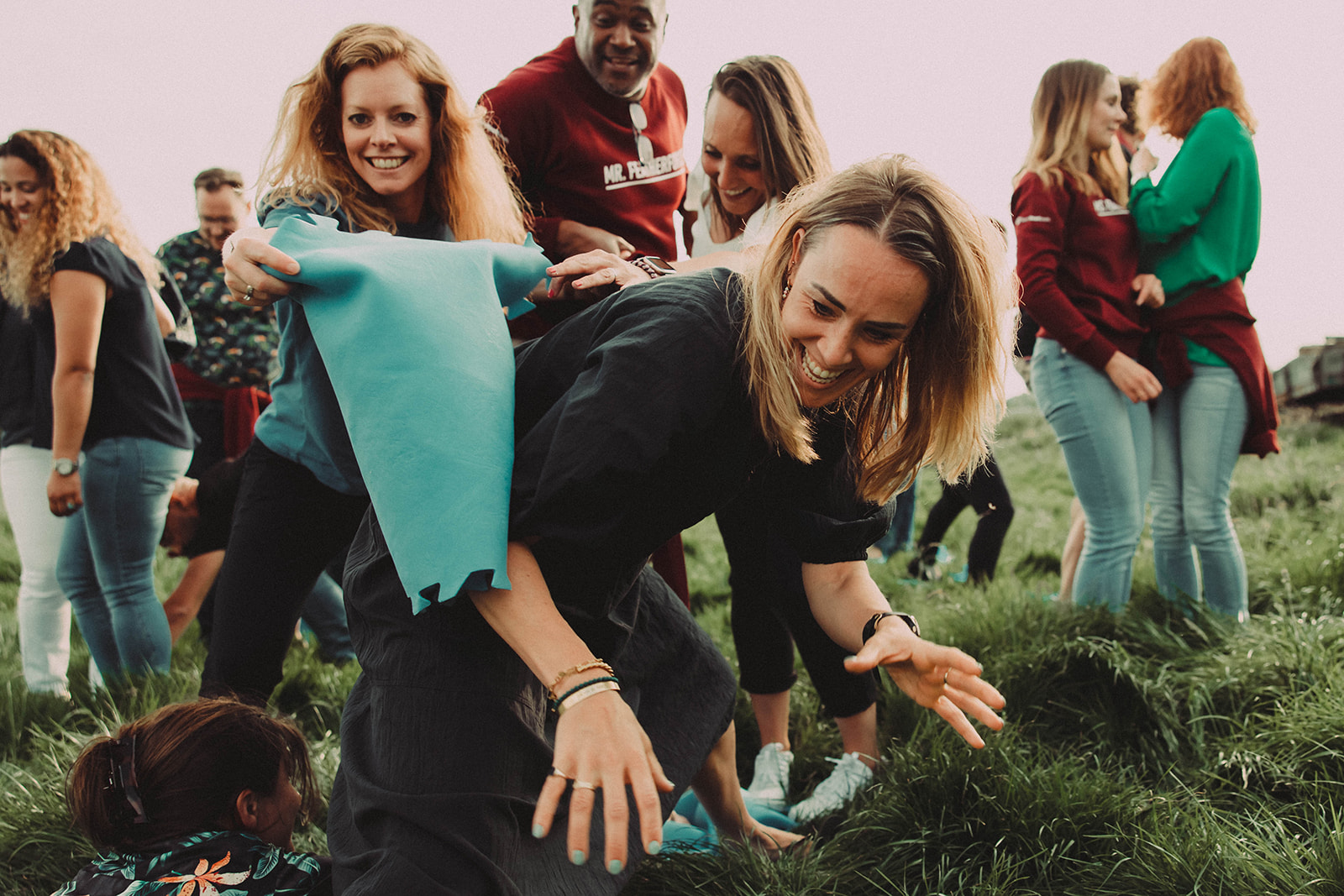 Een groep mensen die tegenslag ervaren tijdens het spelen van een spelletje frisbee in het gras.