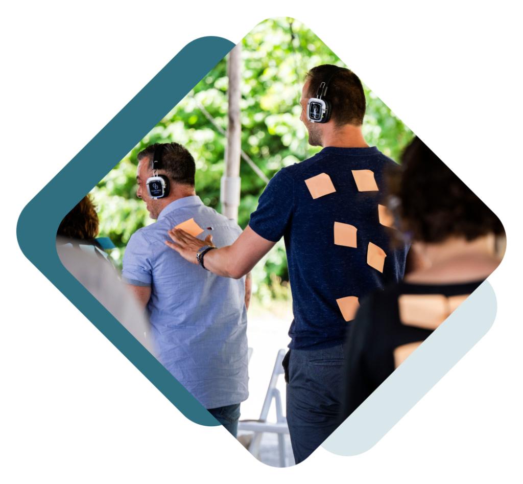 Een groep mensen met plakbriefjes op hun rug, waarop 'ik veer mee'-berichten te zien zijn.